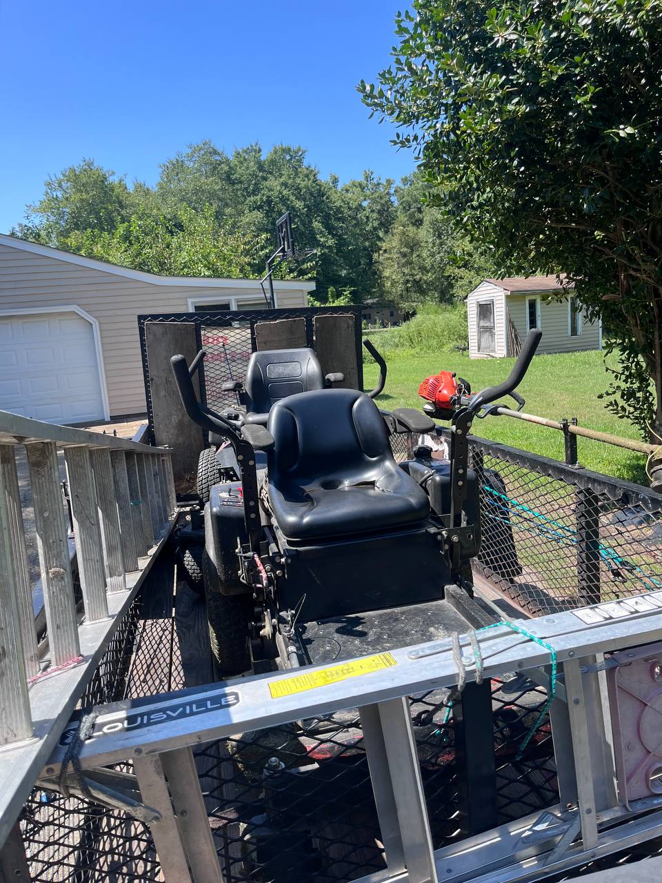 Commercial lawn mower and trimming equipment on a trailer